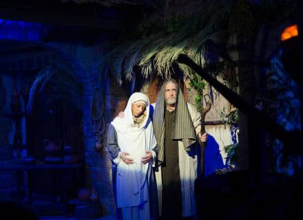 Fotografía de María y José enfrente de la posada con cayado y ella encinta, en el belén viviente de Castro-Urdiales